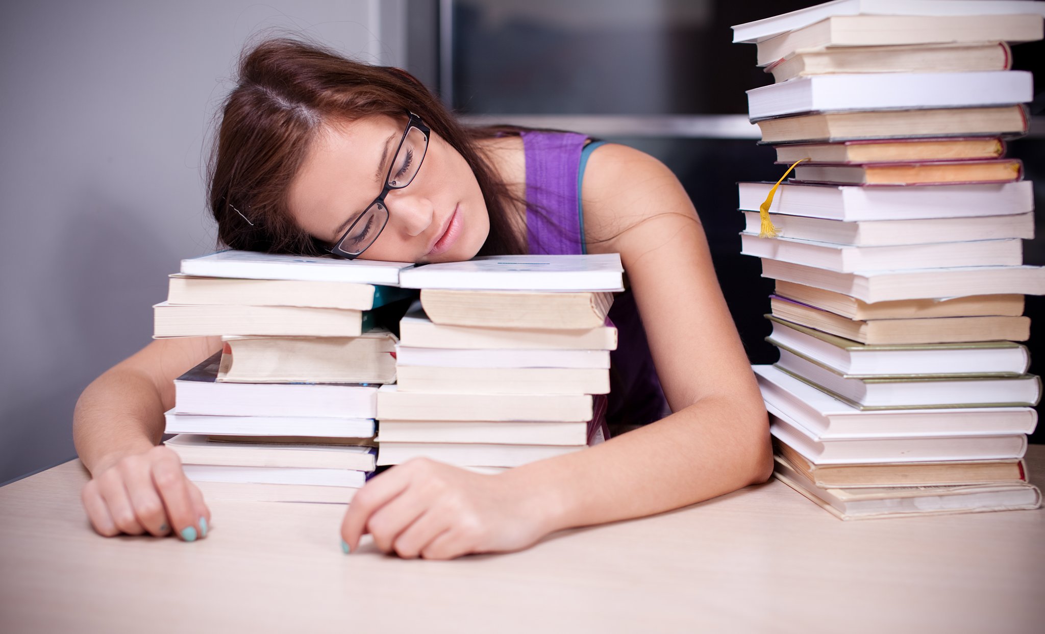 Читать книгу и спать. Сон и учеба. Человек за учебниками. Девушка за учебниками.